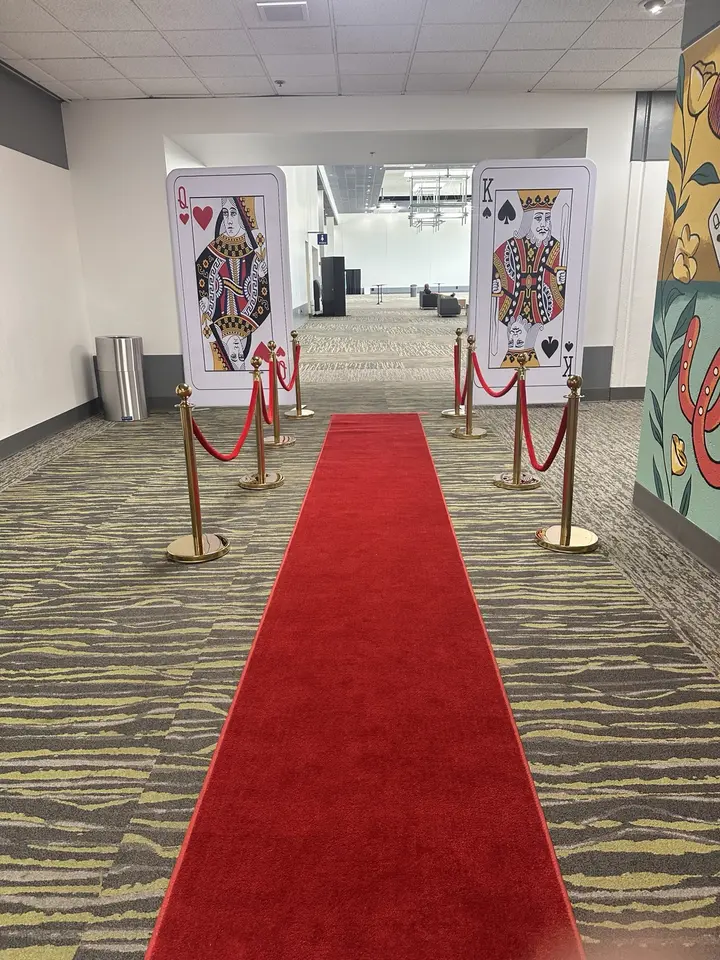 Casino-night red carpet entrance with oversized playing cards