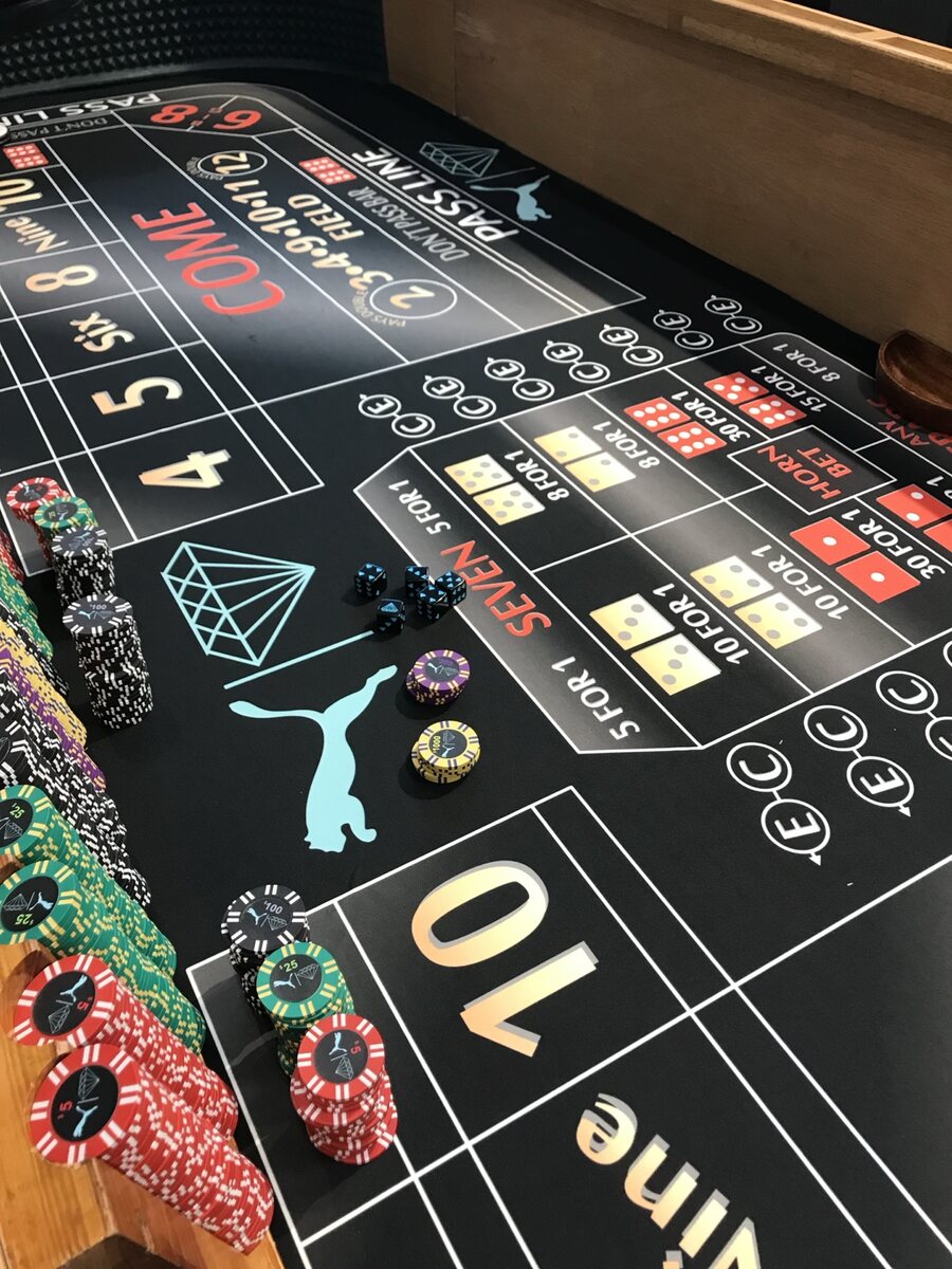 Custom branded craps felt with casino chips prepared for an event
