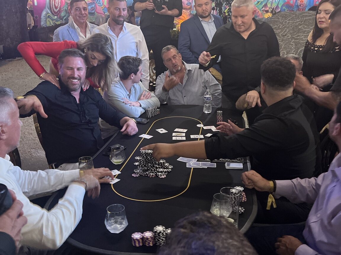 Friends gathered around a professionally staffed poker table at a private birthday celebration