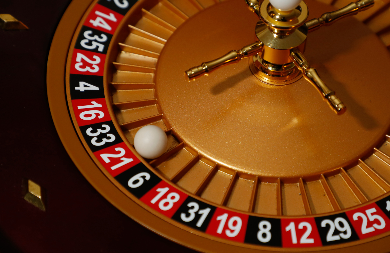 Close-up view of a golden roulette wheel with black and red numbers on it at a 21 Fun casino party event.