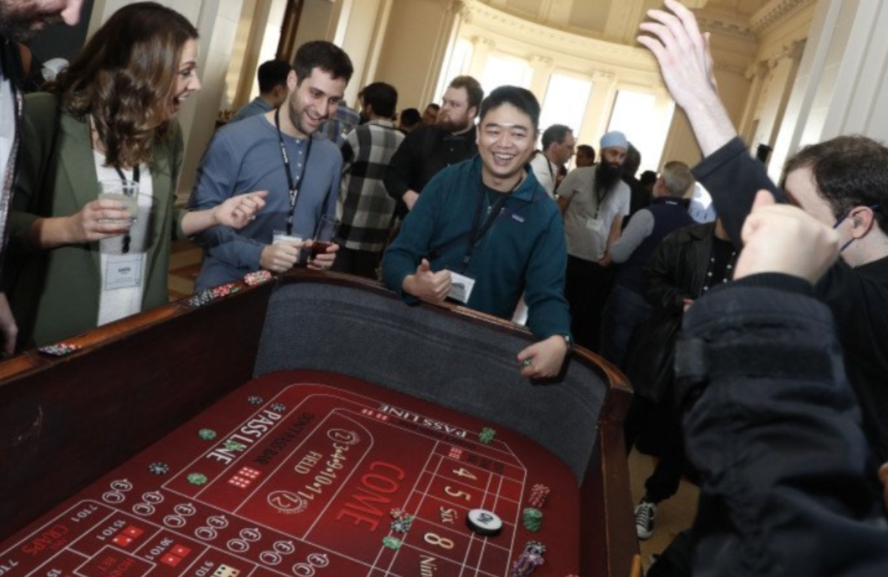 guests smiling and laughing around a casino table at a 21 fun event