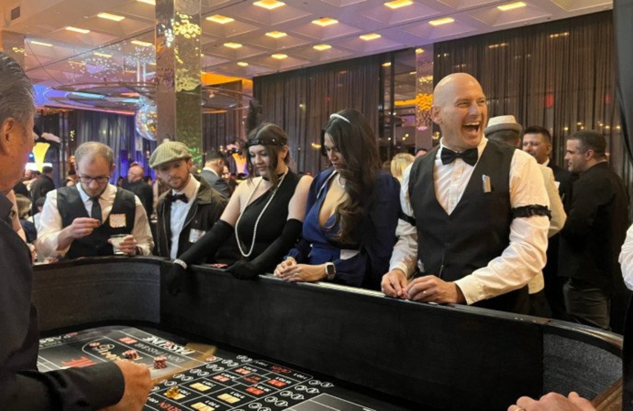 group of people playing around a 21 fun craps table laughing and smiling in roaring twenties era clothing