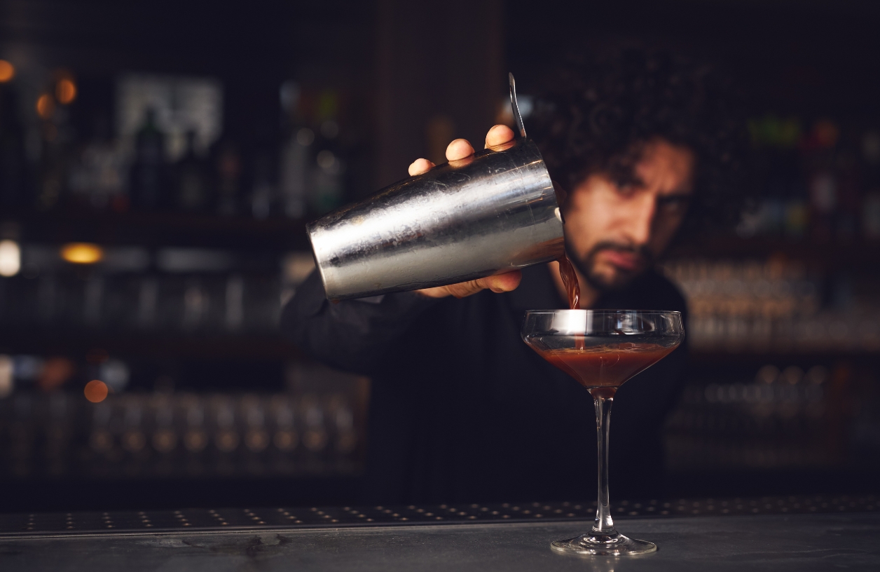 professional bartender serving a shaken martini at a casino night party