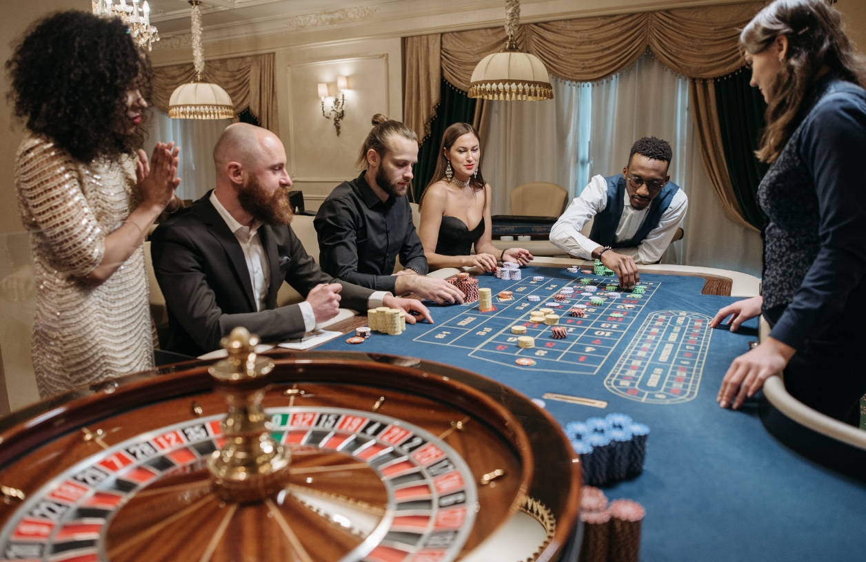 players gathered around a roulette table at a monte carlo casino themed party