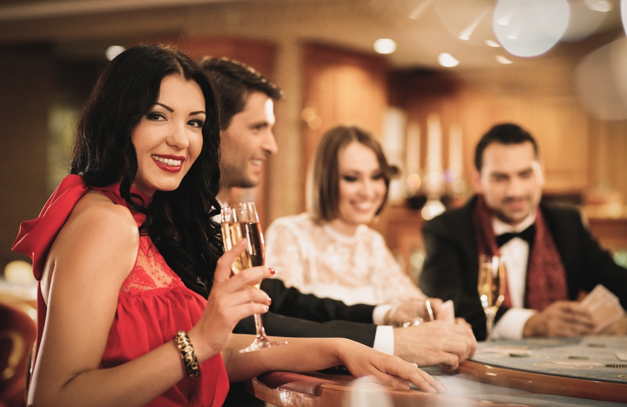 guests at a a casino themed party dressed in classic casino colors red, black, and gold