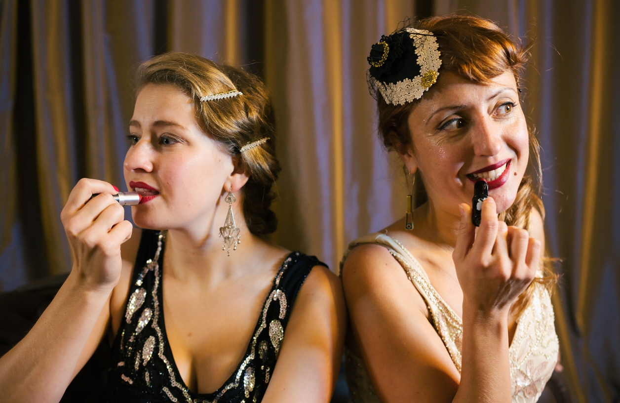 women applying bold lipstick and accessories for a casino themed party