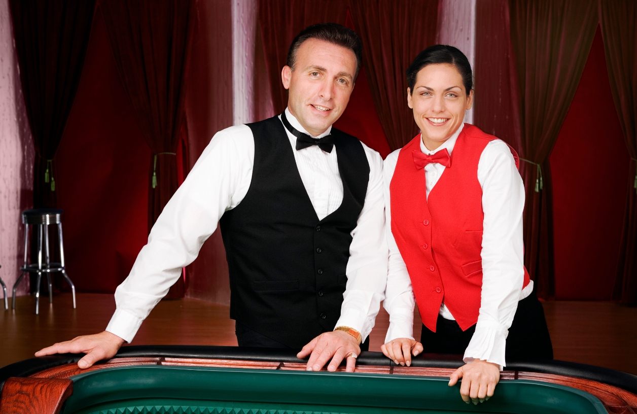 a man and a woman dressed in dealer costumes at a casino themed party