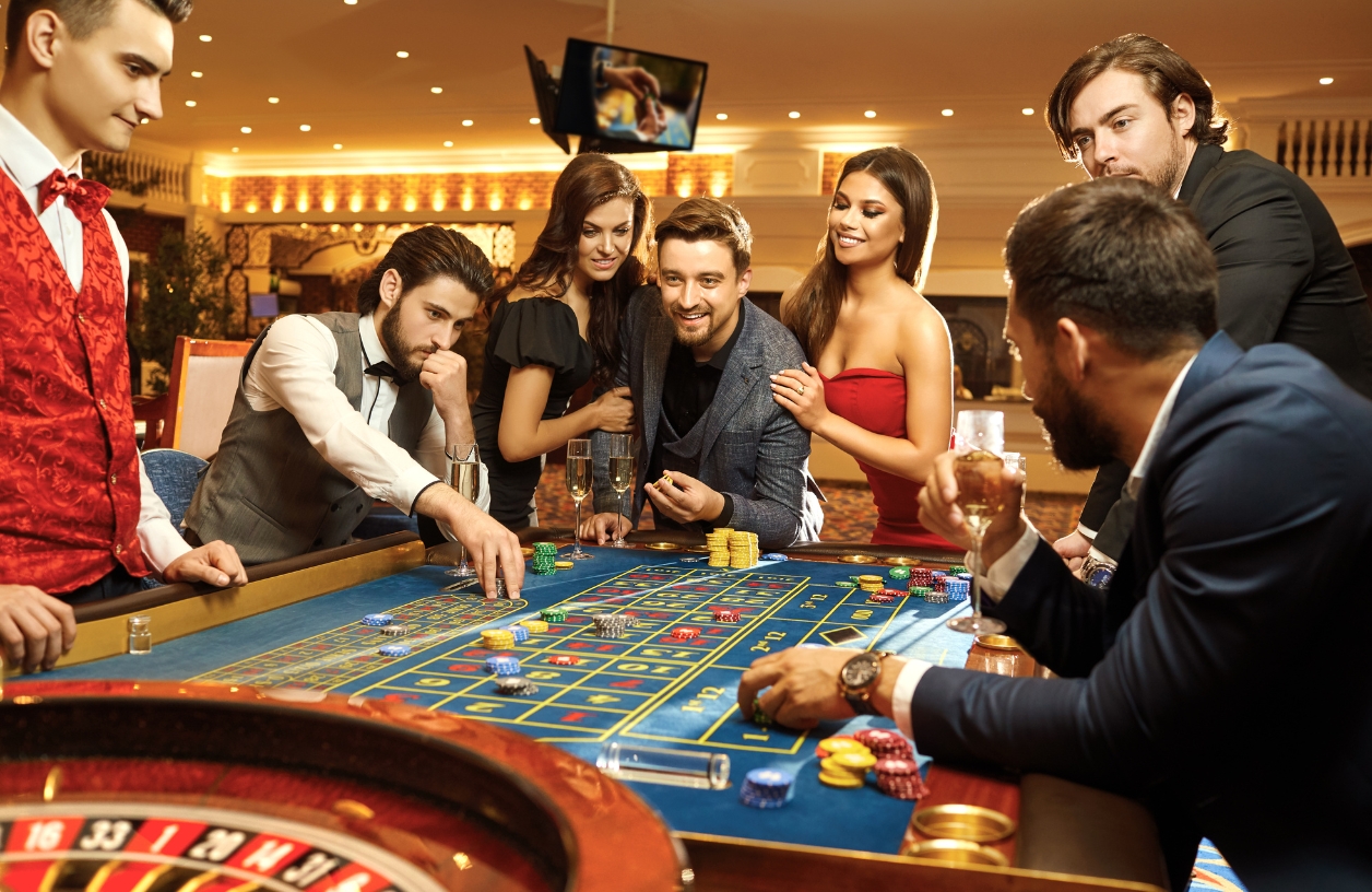 players smiling around a roulette table dressed in elegant attire at a casino themed party